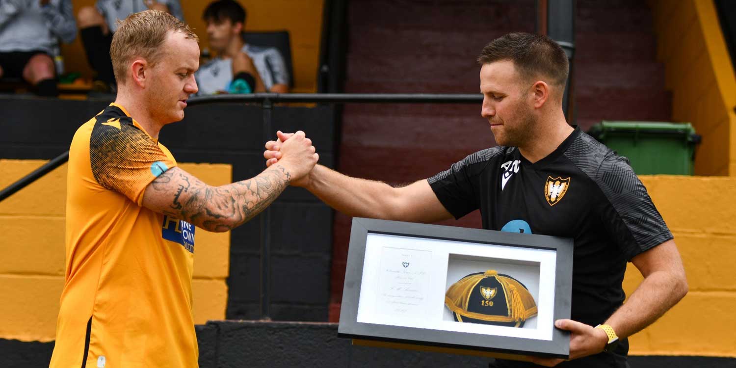 Tom Annear of Falmouth Town AFC receives his cap for reaching 150 appearances for the club.
